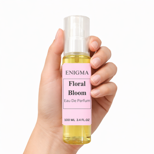 Hand holding a bottle of Enigma Floral Bloom eau de parfum against a white background