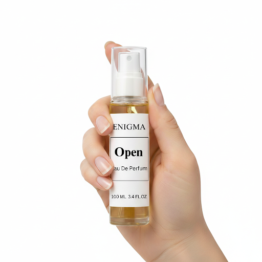 Hand holding a bottle of Enigma Open perfume against a white background
