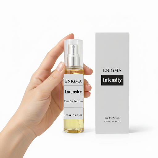Hand holding a 'Enigma Intensity' perfume bottle with its packaging on a white background